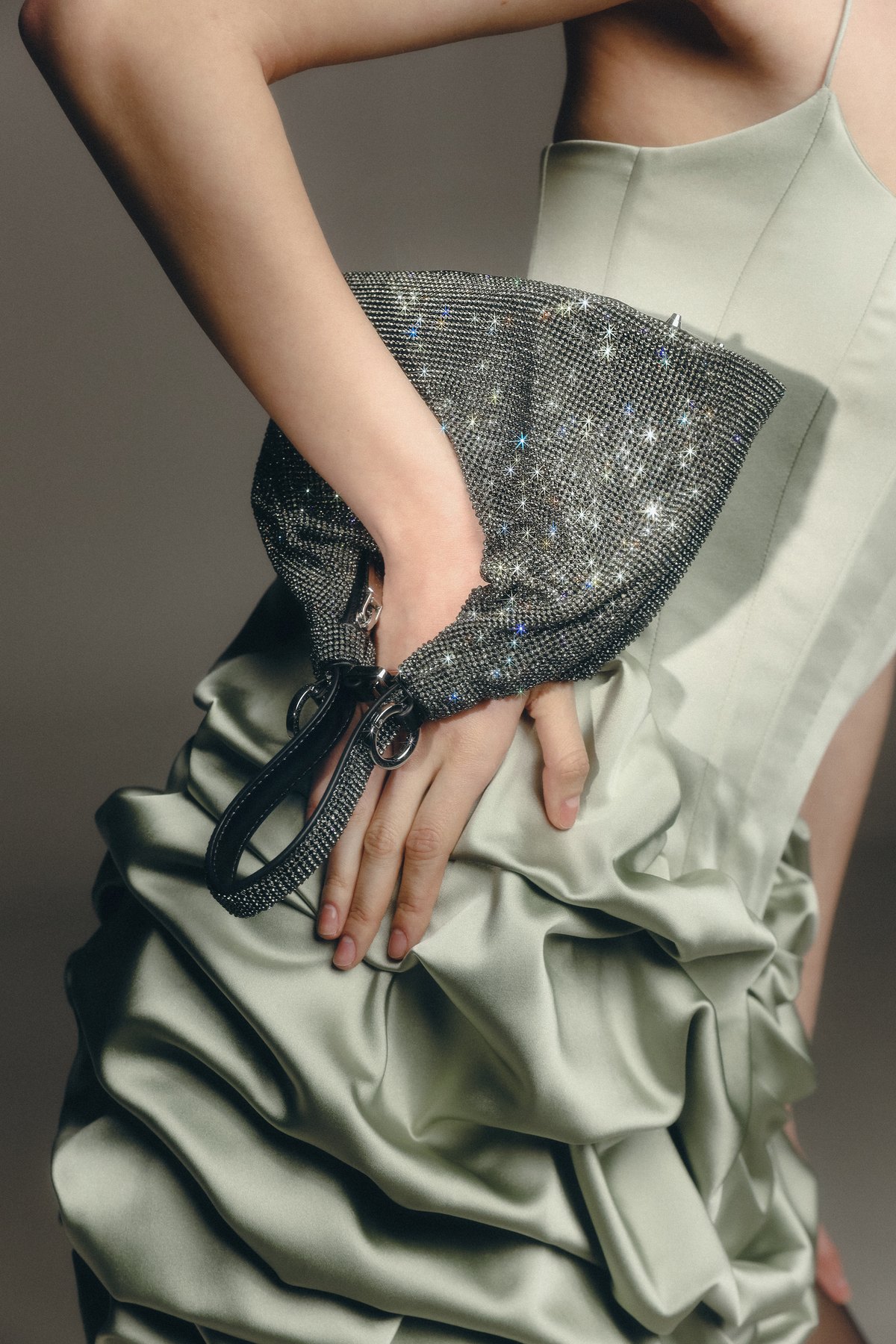 Giarité Jules crystal bag worn on the wrist over a sage satin dress, designed by Georgia Bobar